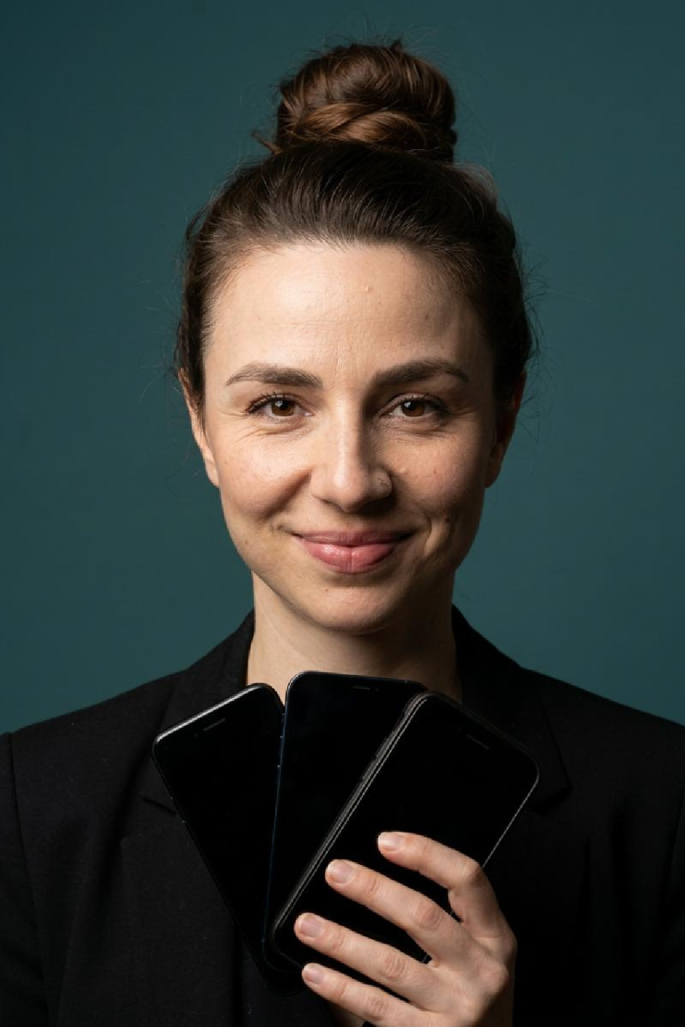 Dr. Maria Kliesch holding three smartphones fanned out like playing cards